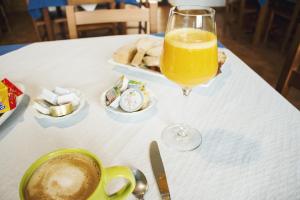 szklankę soku pomarańczowego siedzącą na stole w obiekcie Albergue Camino Norte w mieście Castropol