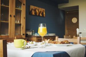 カストロポルにあるAlbergue Camino Norteのオレンジジュースとパンをグラスに入れたテーブル
