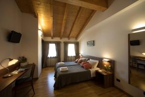 a bedroom with a bed and a desk in a room at Hotel C25 in Ponzano Veneto