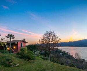 a house on a hill next to a body of water at Locanda Pozzetto in Laveno-Mombello