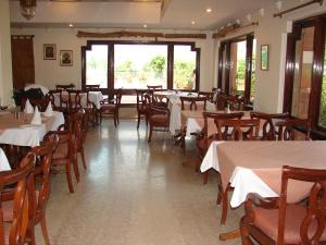 a dining room with tables and chairs with white tablecloths at Mansingh Palace, Ajmer in Ajmer