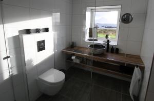 uma casa de banho com um WC, um lavatório e uma janela em Nyksund, Huset på Skåltofta em Nyksund