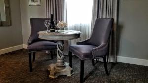 einen Tisch mit 2 Stühlen und einen Tisch mit Weingläsern in der Unterkunft Resort at Eagle Point Golf Club Lodging in Medford