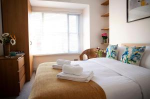 a bedroom with a large bed with towels on it at Apt 1, Opera House 2nd Floor by Indigo Flats in London