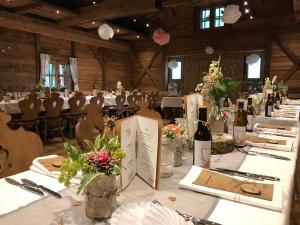 een kamer met een tafel met bloemen en wijnflessen bij Metzgerei Gasthof Oberhauser - Hotel zur Post in Egling