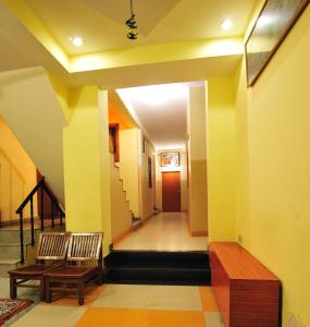 a hallway with two chairs and a table and stairs at Satkar Hotel in Jaipur