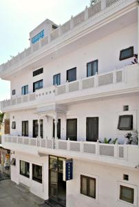 an image of a white building with balconies at Satkar Hotel in Jaipur