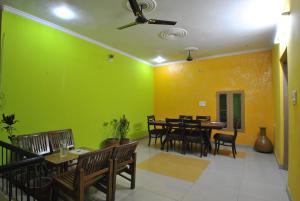 a dining room with green walls and a table and chairs at Satkar Hotel in Jaipur