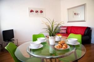 a dining room with a glass table and green chairs at Apt 2, Opera House by Indigo Flats in London