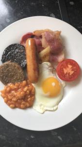 un plato de desayuno con huevos con judías y tocino en bishop gate bnb en Derry