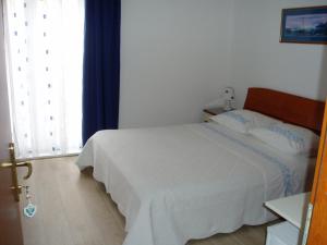 Postel nebo postele na pokoji v ubytování Apartments and Rooms Nikša