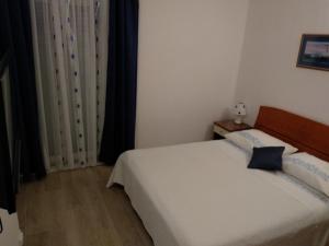 Postel nebo postele na pokoji v ubytování Apartments and Rooms Nikša