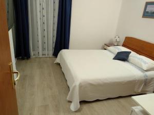 Postel nebo postele na pokoji v ubytování Apartments and Rooms Nikša