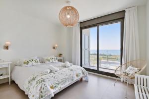 biała sypialnia z łóżkiem i dużym oknem w obiekcie Panorama Beach - Sky View w mieście Torrox Costa +22 zdjęcia