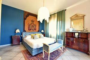 ein Schlafzimmer mit blauen Wänden und einem Bett und einem Stuhl in der Unterkunft Villa Tina in Santa Maria di Castellabate + 90 Fotos