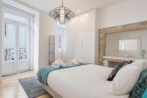 - une chambre blanche avec un grand lit et une fenêtre dans l'établissement LovelyStay - Lusitano's Heart 2BDR Apartment in Alfama, à Lisbonne