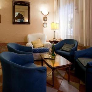 a living room with blue chairs and a table at Hotel Florida in Venice