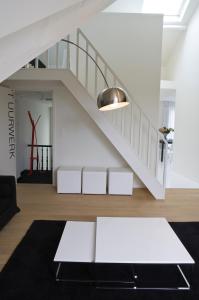 a living room with a staircase and a white table at Leopold5 Luxe-Design Apartment in Ostend