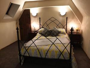 een slaapkamer met een bed met een zwart frame bij The Loft @ Ford House in Yetminster