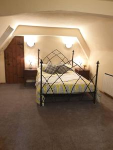 een slaapkamer met een bed in een kamer met 2 tafels bij The Loft @ Ford House in Yetminster