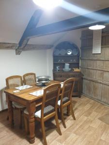 a kitchen with a wooden table and chairs and a stove at The Loft @ Ford House in Yetminster