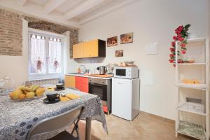 a kitchen with a table with a bowl of fruit on it at b&b sotto le torri in Albenga