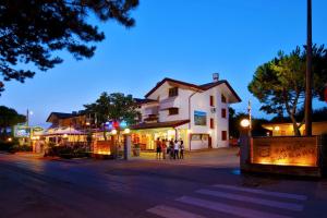 a group of people walking down a street at night at Camping Parco Capraro in Lido di Jesolo