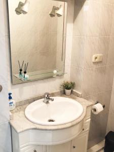 y baño con lavabo blanco y espejo. en Pitelos Apartment, en Santiago de Compostela