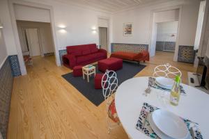 sala de estar con sofá rojo y mesa en Luxurious Cais do Sodre - 4 bedrooms with amazing view, en Lisboa