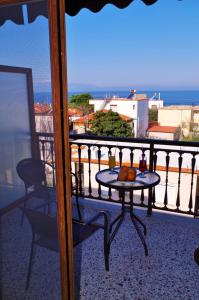 a table on a balcony with a view of the ocean at Sotiras Rooms in Skala Sotiros
