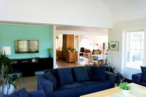 uma sala de estar com um sofá e uma sala de jantar em Sun All Day House em Svartsjö