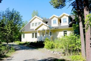 una casa blanca con una entrada delante de ella en Sun All Day House en Svartsjö