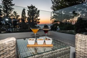 stolik z dwoma kieliszkami wina i dwie miski popcornu w obiekcie Luxury apartment SUNSET with private pool and jacuzzi w Novalji