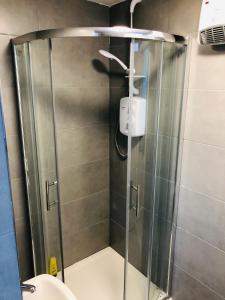 a shower with a glass door in a bathroom at Southend - Westcliff Apartments & Studios in Southend-on-Sea