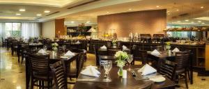 a restaurant with tables and chairs and a bar at Sol Alphaville Hotel & Residence in Barueri