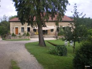 a house with a tree and a gravel driveway at GITE de la RENAISSANTE in Peyrins