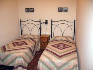 1 dormitorio con 2 camas y mesita de noche en Casa Magdalena Autural, en Siresa