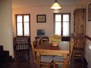 a dining room with a table and chairs and a television at Casa Magdalena Autural in Siresa