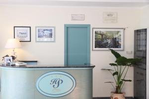 a reception desk in a hotel room with a mirror at Aviano Palace Hotel in Aviano