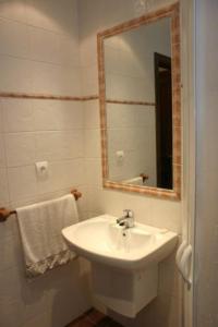 Baño blanco con lavabo y espejo en Casa Magdalena Autural, en Siresa