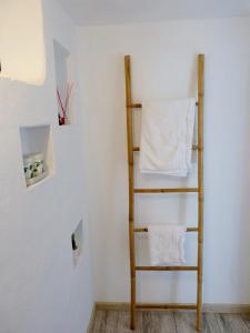 a shelf in a room with white walls and white towels at Casa Lantana in Figueira da Foz