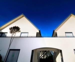 a white house with a blue sky behind it at Bella Vista Motel Invercargill in Invercargill +9 photos