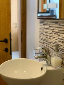 umywalkę w łazience z dozownikiem mydła na ladzie w obiekcie Ascot By The Sea w mieście St Paul's Bay