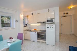 a kitchen with white appliances and a table and a table and a table sidx sidx at Apartment Sugar Flat in Split