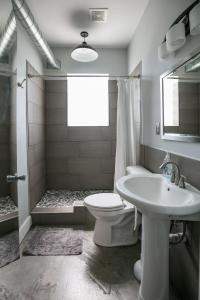 La salle de bains est pourvue de toilettes, d'un lavabo et d'une douche. dans l'établissement Hostel Detroit, à Detroit