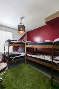 a room with three bunk beds and a green rug at Hostel Detroit in Detroit