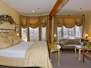a bedroom with a large bed and a living room at Hotel Sausalito in Sausalito