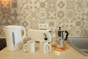 una encimera de cocina con tostadora y tazas. en Beach and Family, en Vélez-Málaga