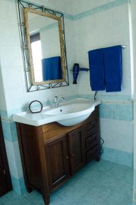 a bathroom with a sink and a mirror and blue towels at B&B Tribunale in Cosenza