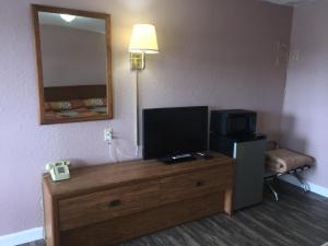 a hotel room with a television on a wooden dresser at Finn's Motel in Saint James